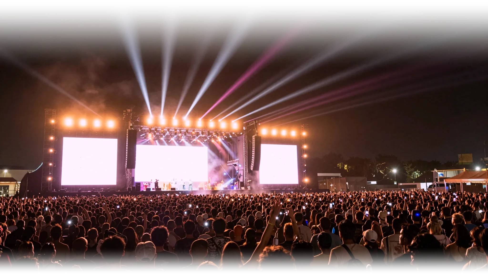 The main stage at night, lights over an enormous crowd